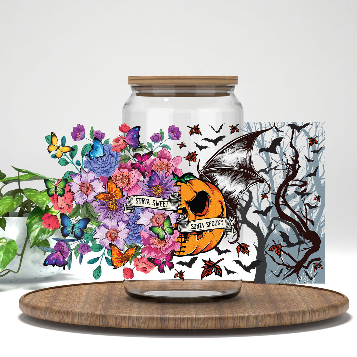 Sorta Sweet Sorta Spooky floral pumpkin and bat wing UV DTF wrap on a clear glass can