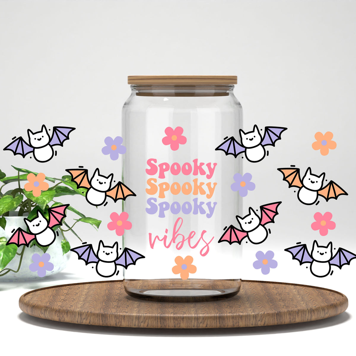 Spooky Vibes pastel bats and daisies UV DTF full wrap on a clear glass can