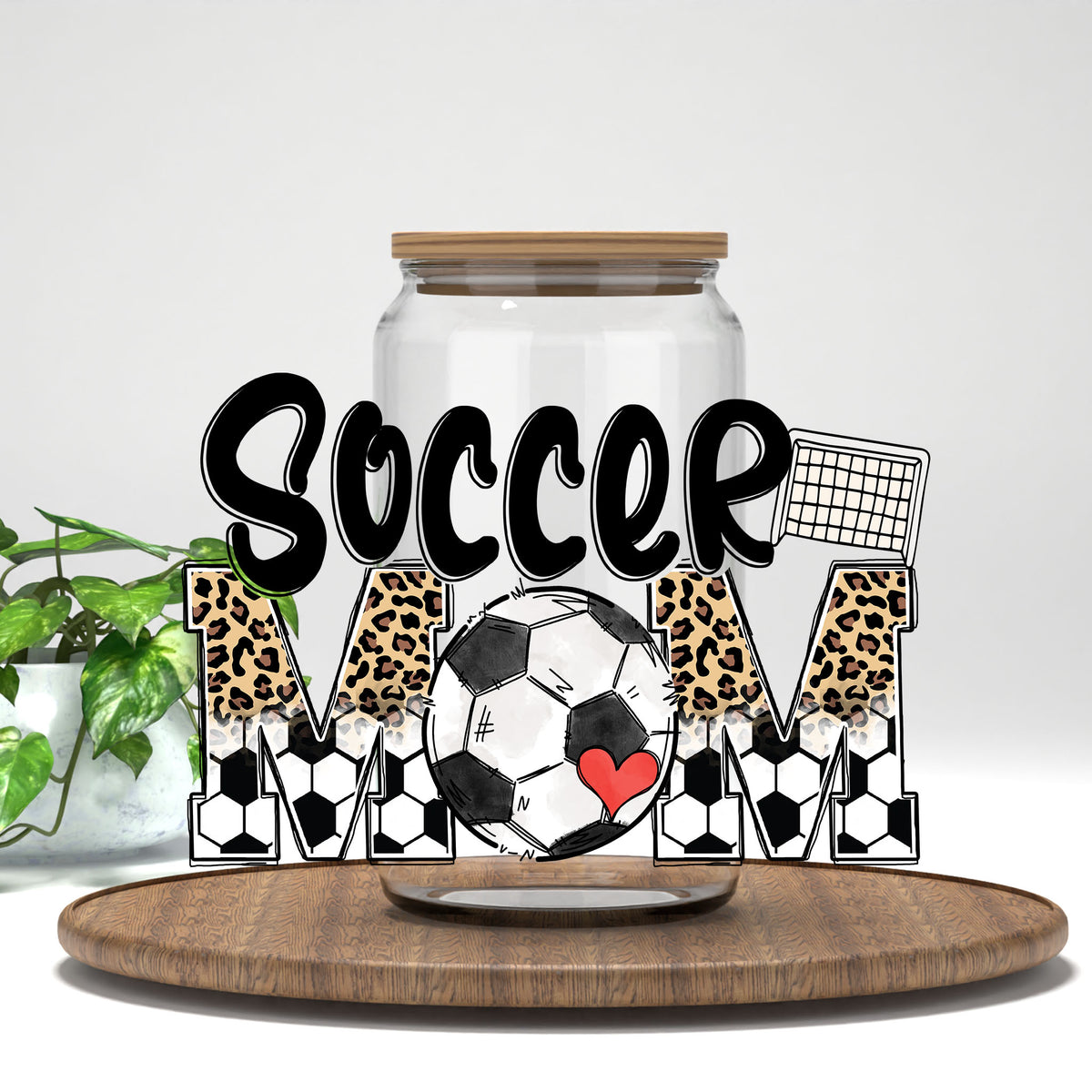 Soccer Mom leopard and soccer ball letters UV DTF wrap on a clear glass can