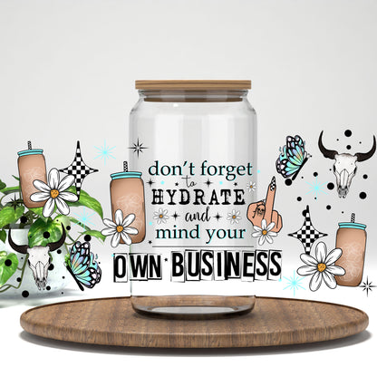 Don't Forget to Hydrate and Mind Your Own Business UV DTF wrap on a clear glass can