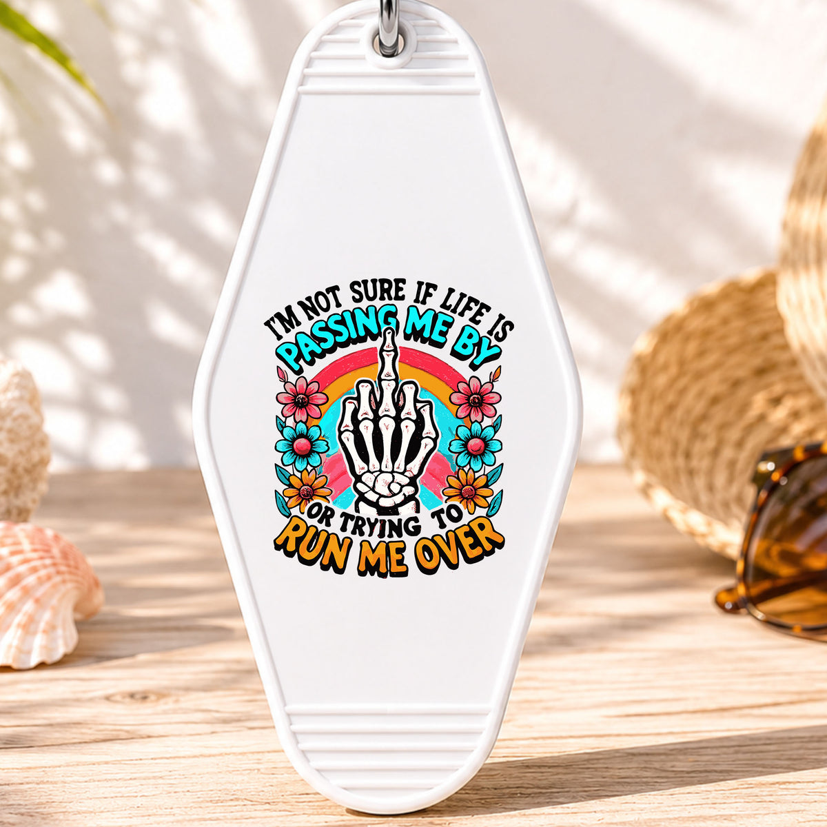 Passing Me By or Running Me Over UV DTF transfer on a white motel keychain with beach decor