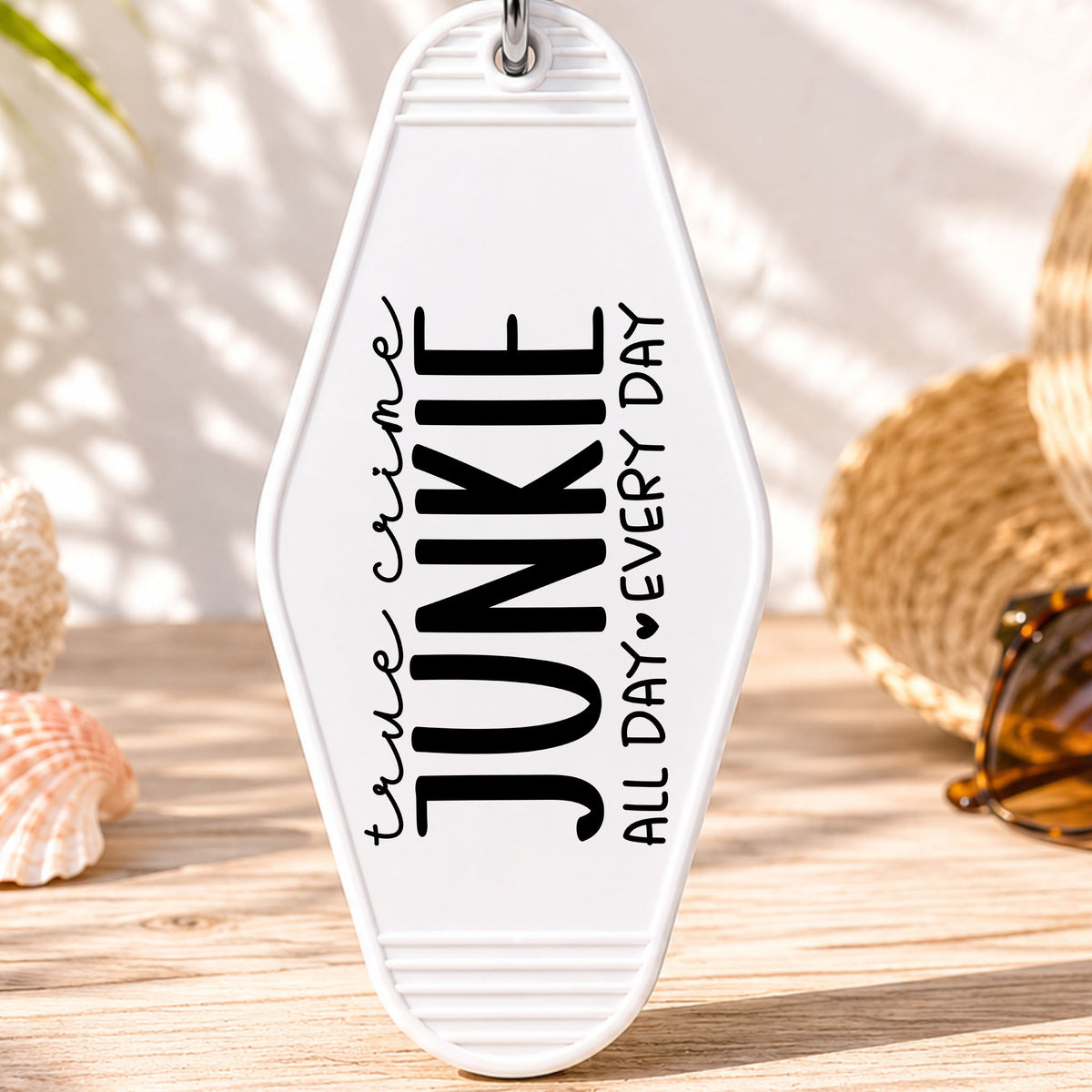 True Crime Junkie UV DTF transfer on a white motel keychain with beach decor