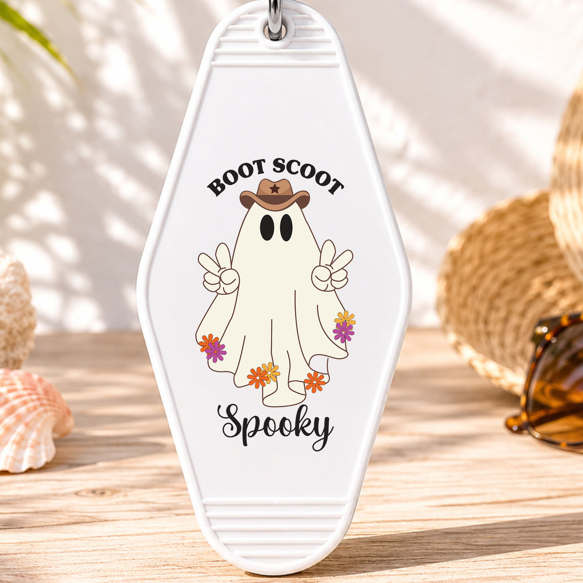 Boot Scoot Spooky UV DTF transfer on a white motel keychain with beach decor