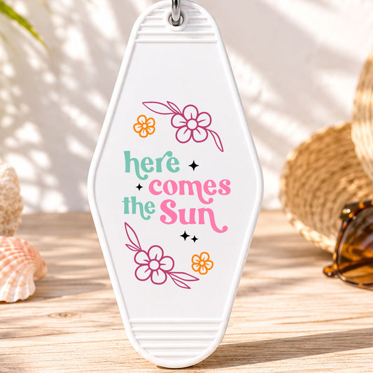 Here Comes the Sun UV DTF transfer on a white motel keychain with beach decor