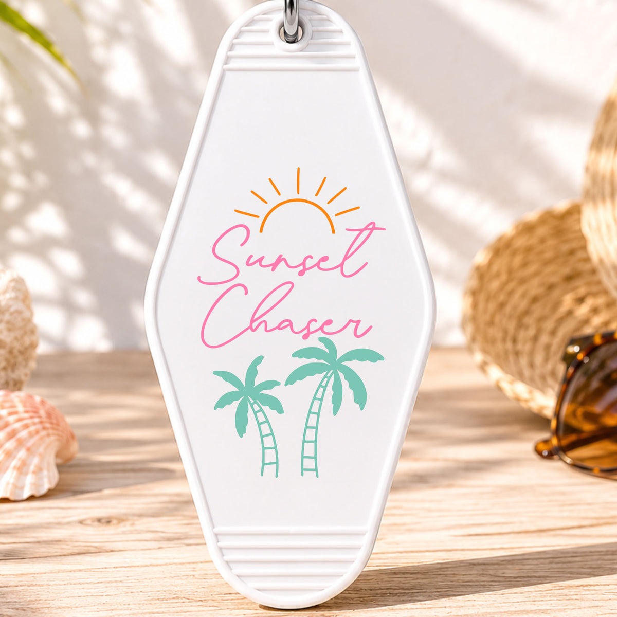 Sunset Chaser UV DTF transfer on a white motel keychain with beach decor