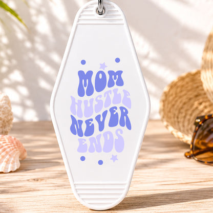 Mom Hustle Never Ends UV DTF transfer on a white motel keychain with beach decor