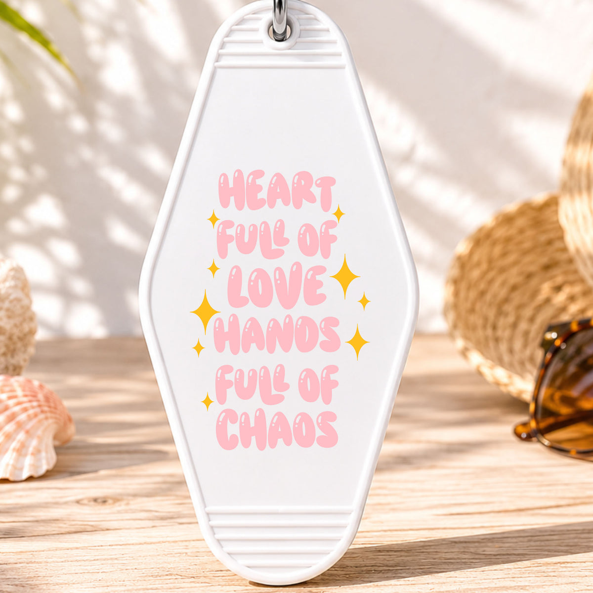 Heart Full of Love Hands Full of Chaos UV DTF transfer on a white motel keychain with beach decor