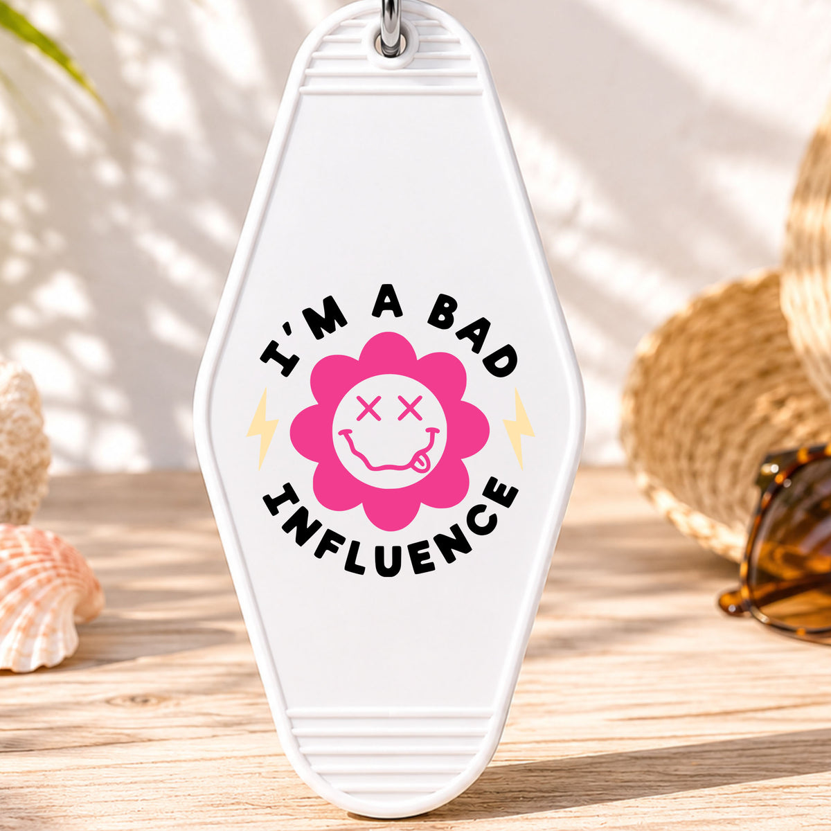 I'm a Bad Influence UV DTF transfer on a white motel keychain with beach decor