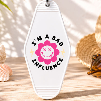 I'm a Bad Influence UV DTF transfer on a white motel keychain with beach decor