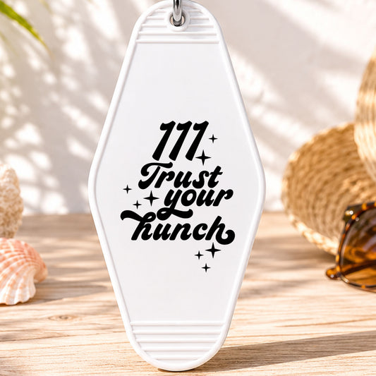 111 Trust Your Hunch UV DTF transfer on a white motel keychain with beach decor