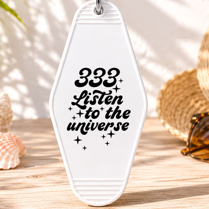 333 Listen to the Universe UV DTF transfer on a white motel keychain with beach decor