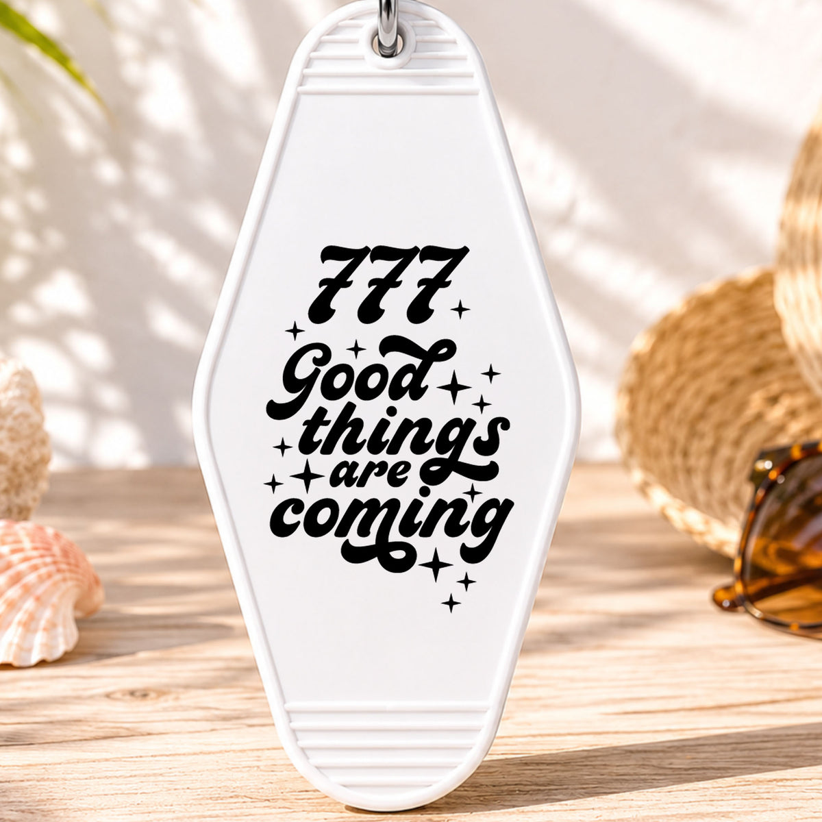 777 Good Things Are Coming UV DTF transfer on a white motel keychain with beach decor