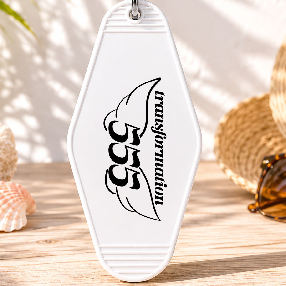 555 Transformation UV DTF transfer on a white motel keychain with beach decor