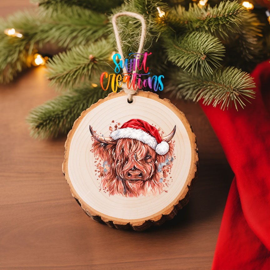 Highland Cow Santa Hat UV DTF transfer on a wood slice ornament with pine branches and a red stocking