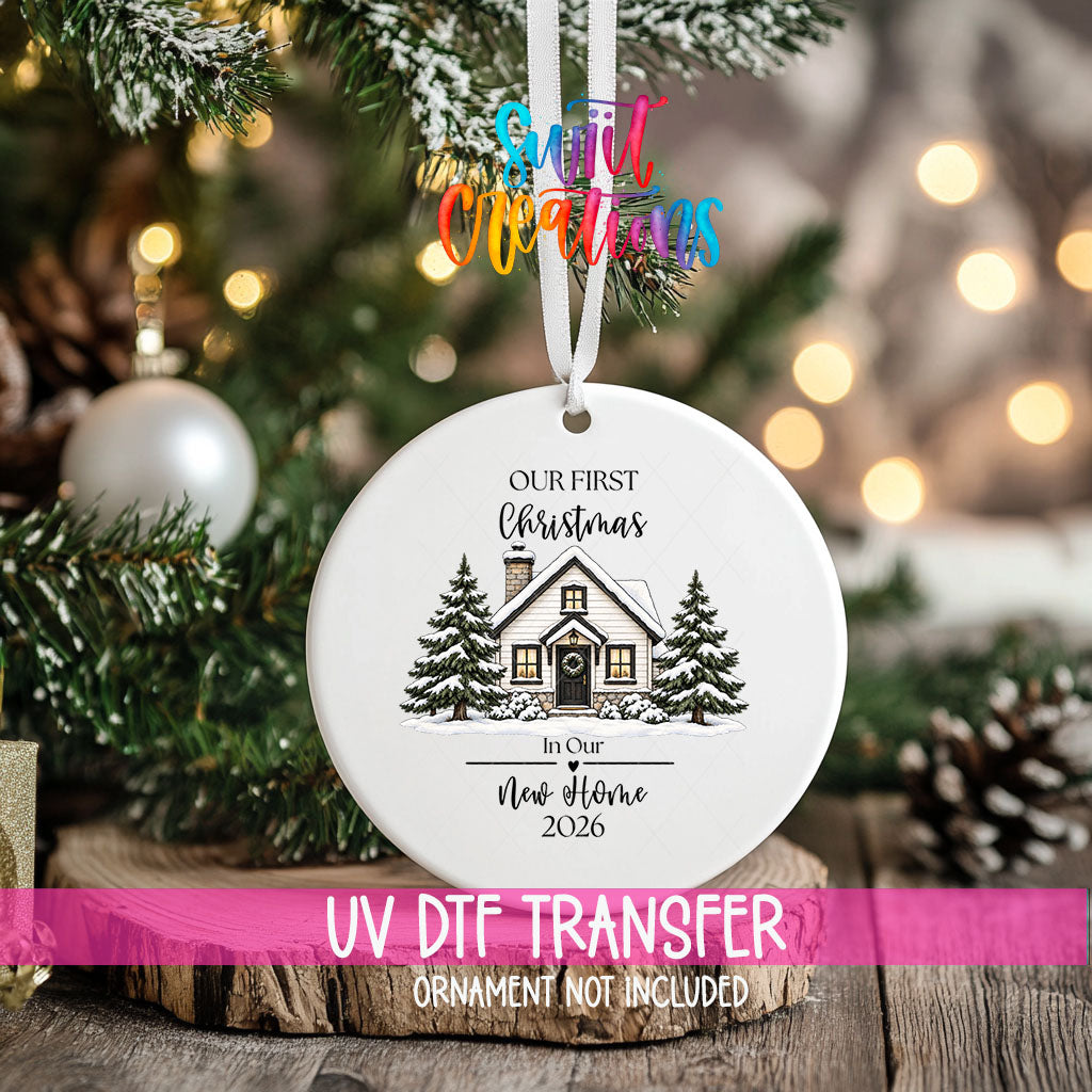 Our First Christmas New Home ornament UV DTF transfer on an ornament resting on a wood slice beside a Christmas tree