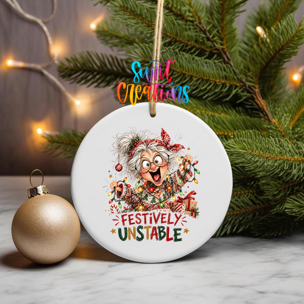 Festively Unstable ornament UV DTF transfer on a hanging ornament with pine branches and a gold bauble