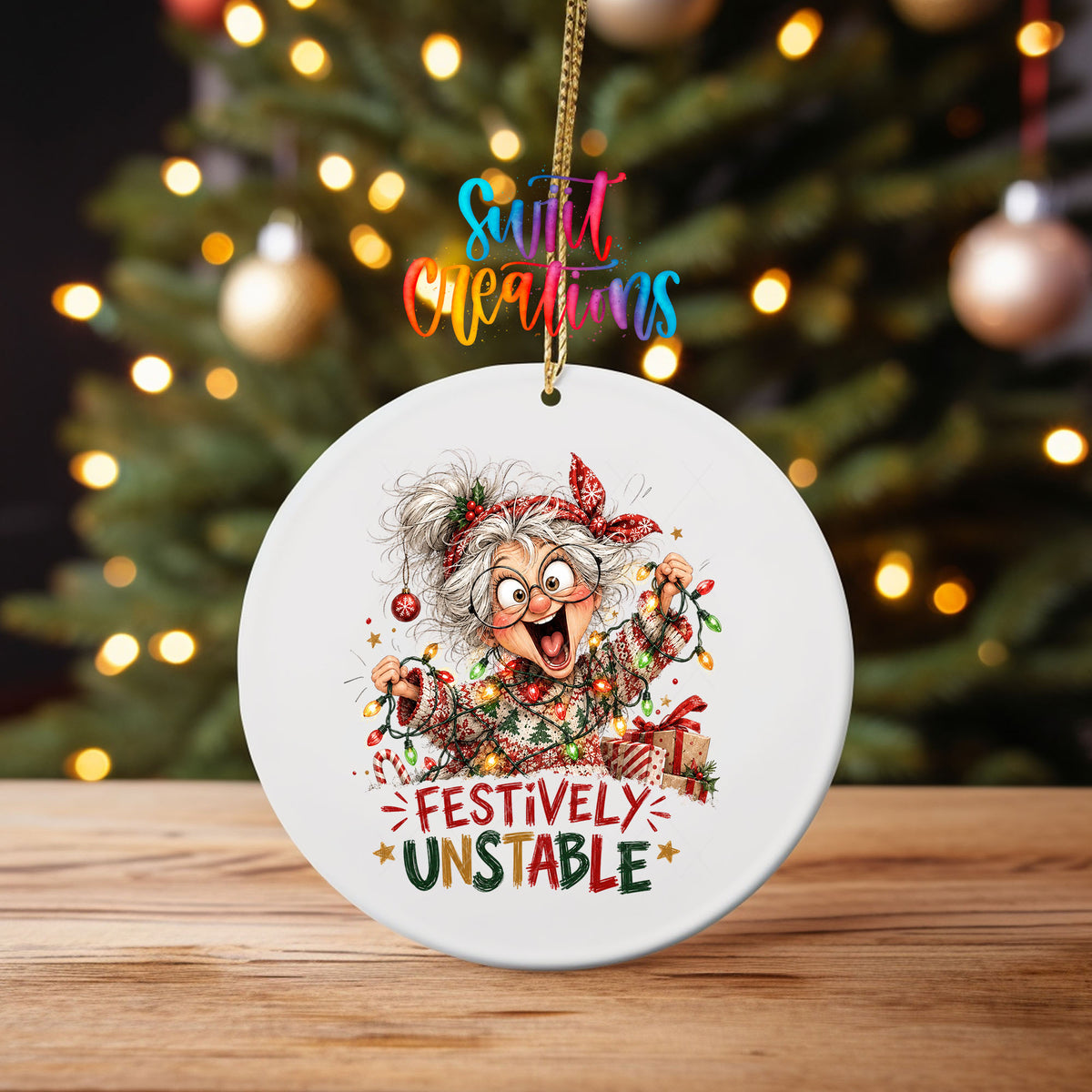 Festively Unstable ornament UV DTF transfer on an ornament on a wooden table with tree lights behind it