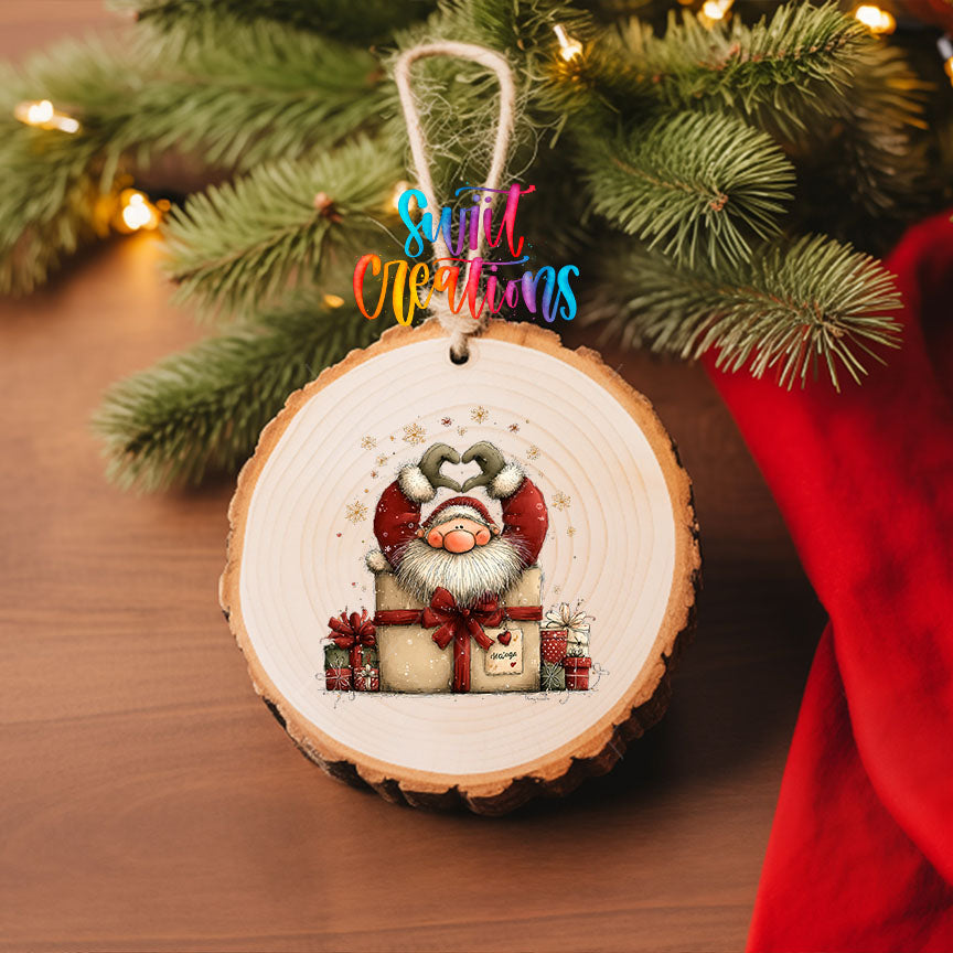 Cute Santa in a gift box UV DTF transfer on a wood slice ornament with pine branches and a red stocking