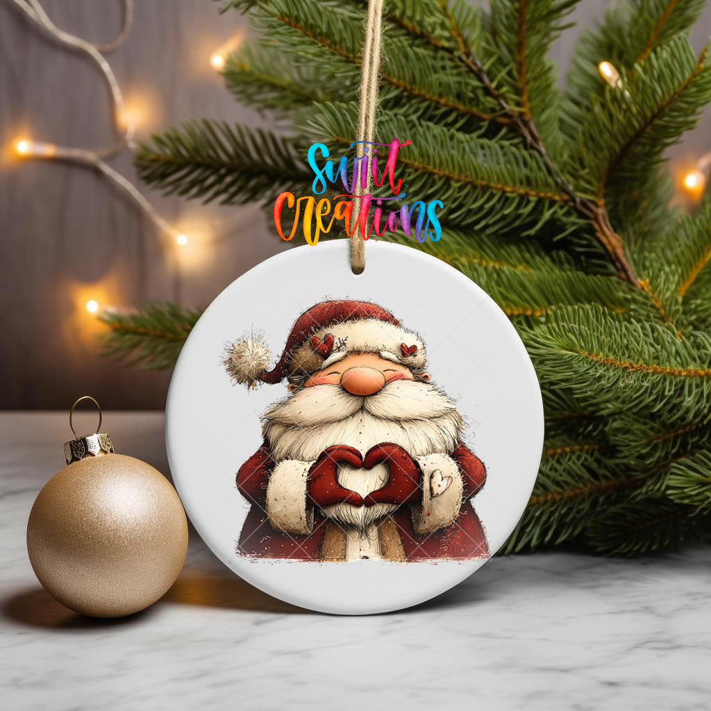 Cute Santa making heart hands ornament UV DTF transfer on a hanging ornament with pine branches and a gold bauble