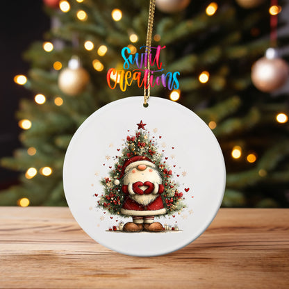 Cute Santa with heart hands in front of a Christmas tree ornament UV DTF transfer on an ornament on a wooden table with tree lights behind it