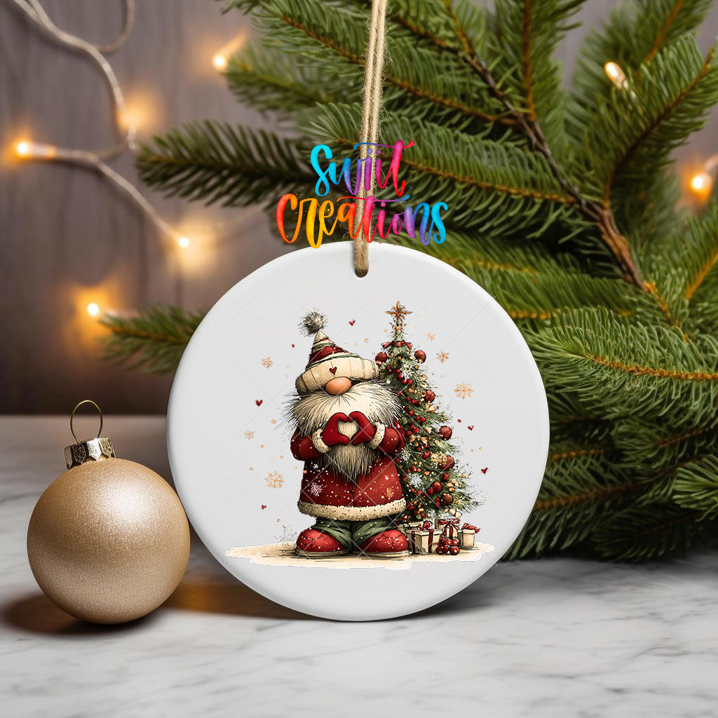 Cute Santa in a knit hat beside a Christmas tree ornament UV DTF transfer on a hanging ornament with pine branches and a gold bauble