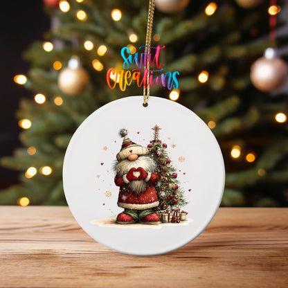 Cute Santa in a knit hat beside a Christmas tree ornament UV DTF transfer on an ornament on a wooden table with tree lights behind it