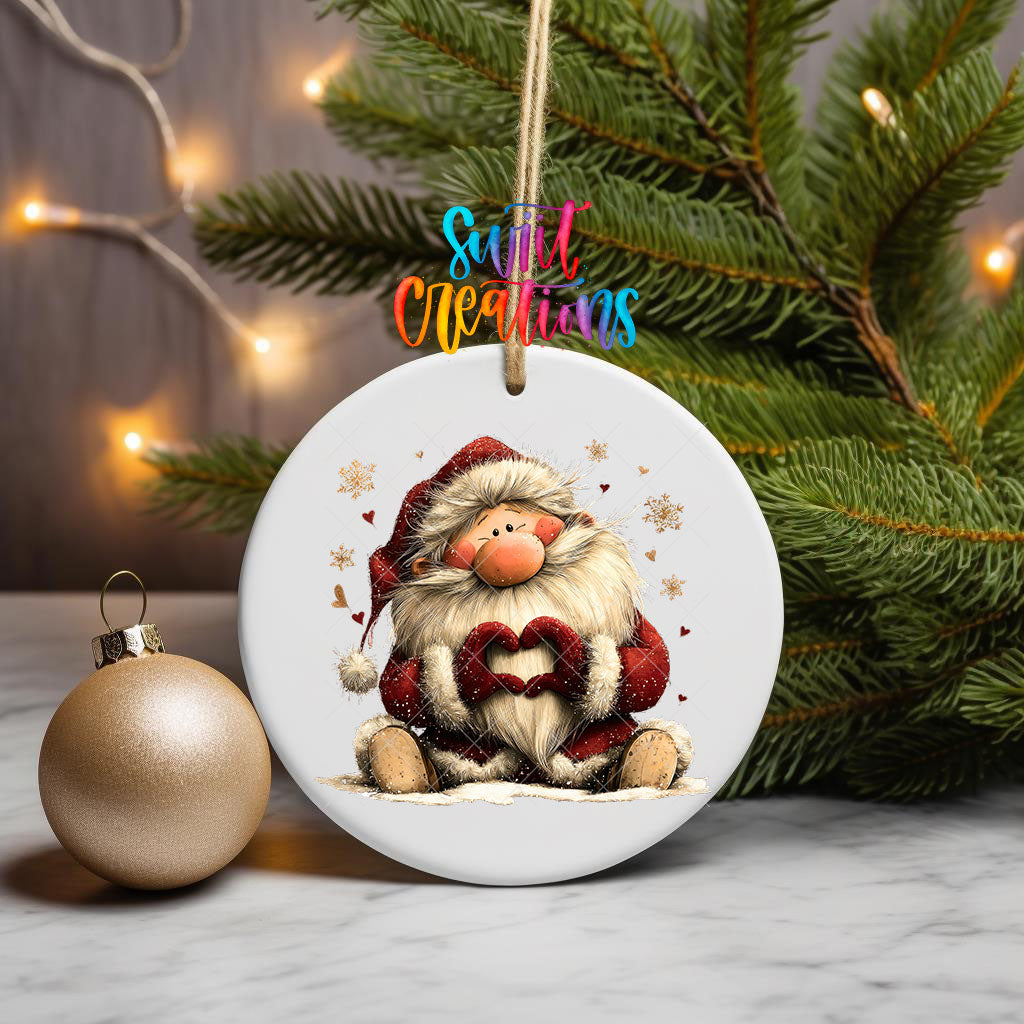 Cute sitting Santa making heart hands ornament UV DTF transfer on a hanging ornament with pine branches and a gold bauble