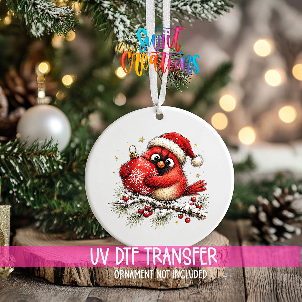 Santa hat cardinal hugging an ornament UV DTF transfer on an ornament hanging in a Christmas tree