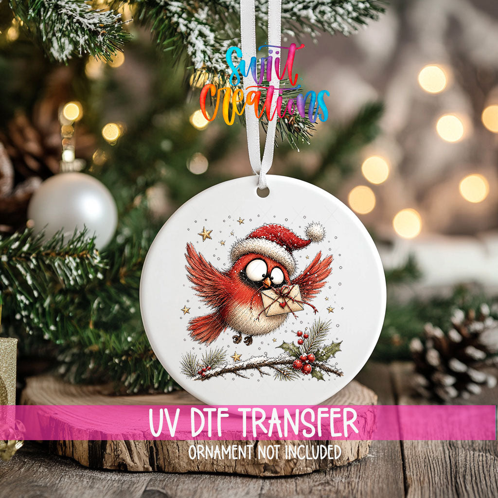Flying cardinal with a heart envelope UV DTF transfer on an ornament hanging in a Christmas tree