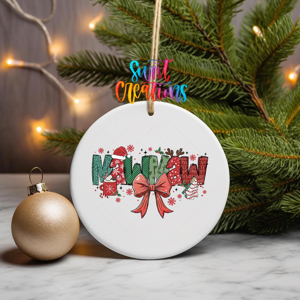 Mawmaw grandma name UV DTF transfer on an ornament hanging from pine branches beside a gold bauble