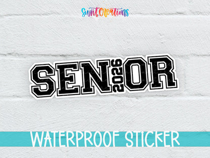 Senior 2026 sticker in black varsity letters on a white brick background with a waterproof sticker banner