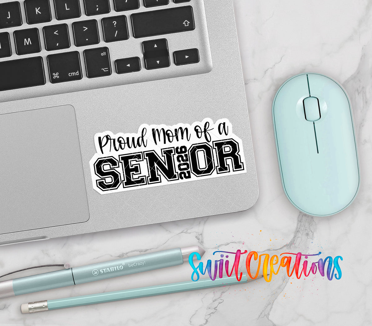 Proud Mom of a 2026 Senior vinyl sticker on a silver laptop next to a mint mouse and pens