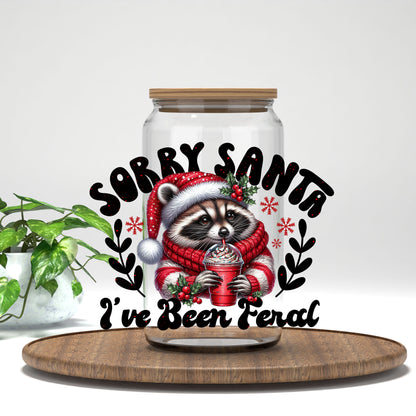 Sorry Santa I've Been Feral raccoon in a red sweater UV DTF transfer on a clear glass can