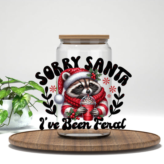 Sorry Santa I've Been Feral raccoon in a red sweater UV DTF transfer on a clear glass can