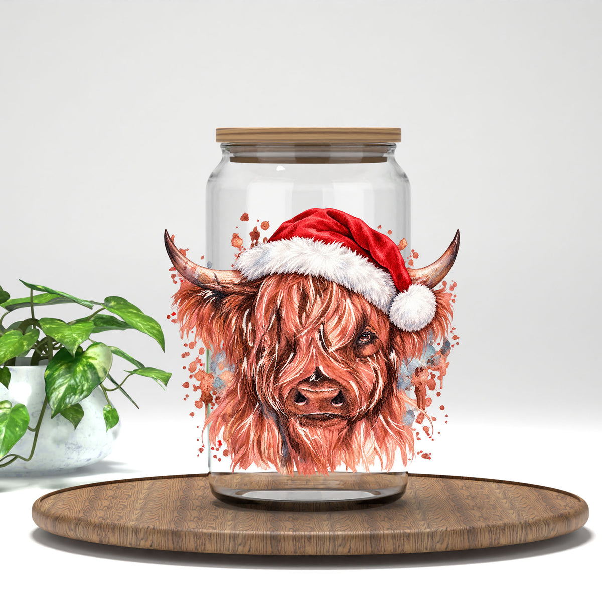 Cow With Santa Hat UV DTF transfer on a clear glass can with a bamboo lid