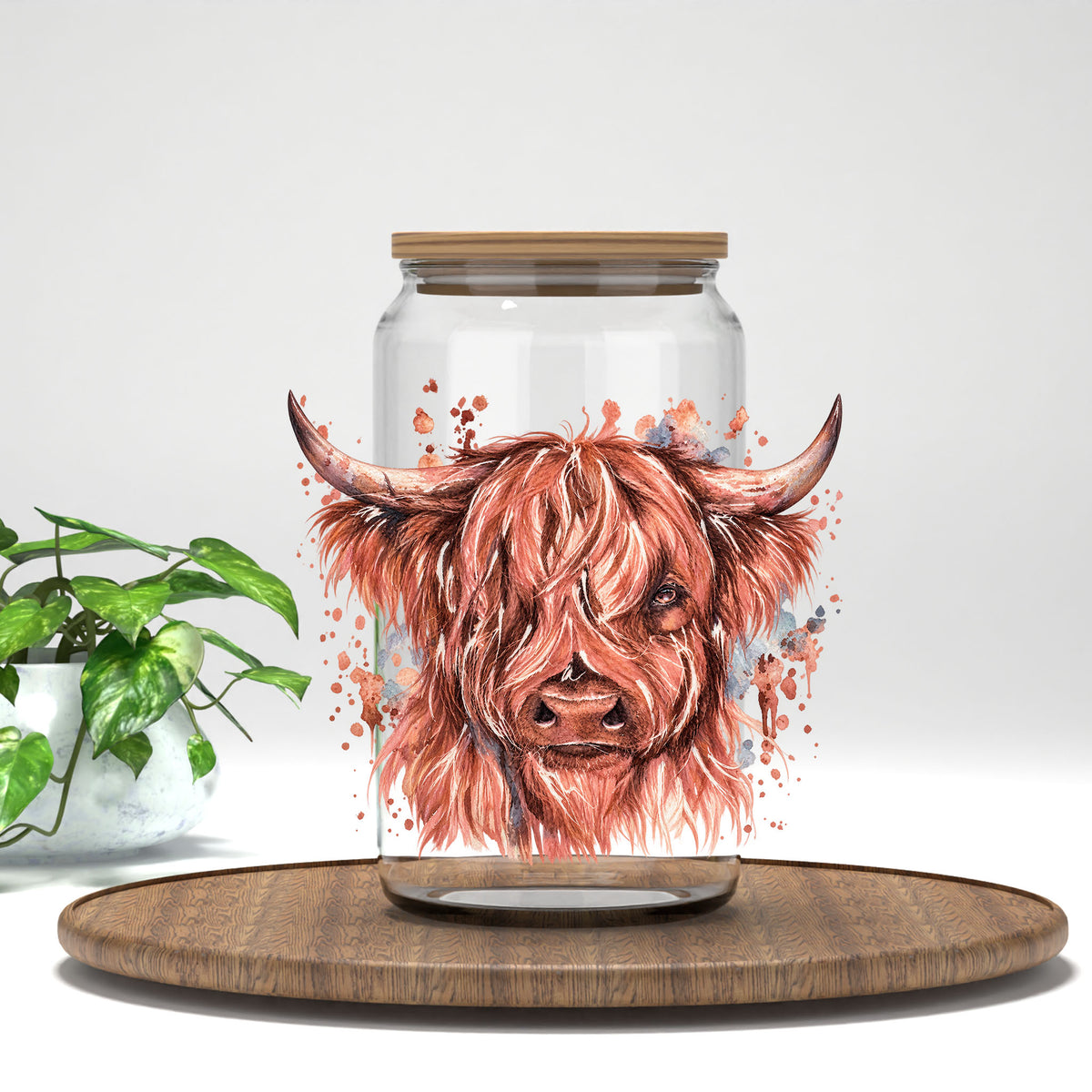 Highland Cow rose-toned watercolor UV DTF transfer on a clear glass can with a bamboo lid