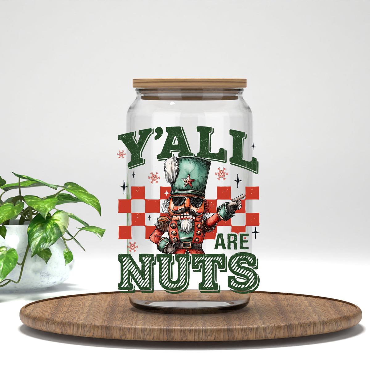 Y'all Are Nuts nutcracker UV DTF transfer on a clear glass can with a bamboo lid