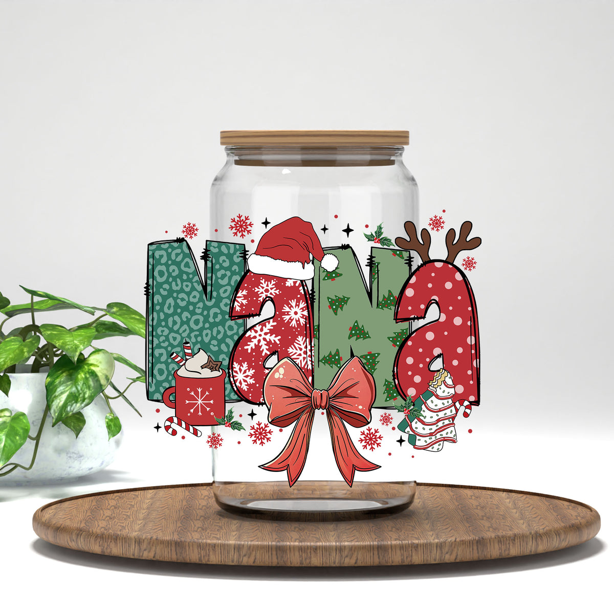 Nana Christmas UV DTF transfer on a clear glass can on a wood tray with greenery