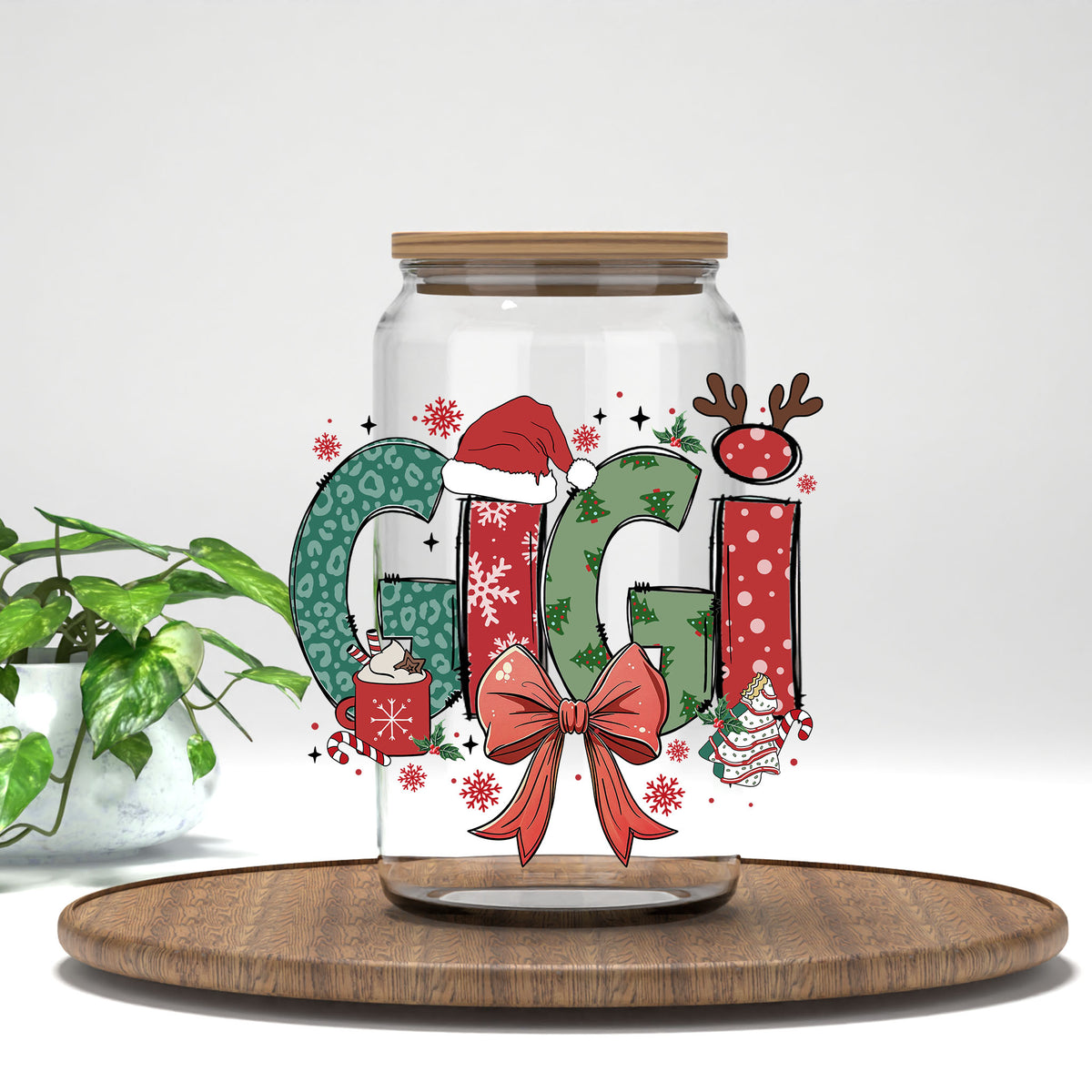 Gigi Christmas UV DTF transfer on a clear glass can on a wood tray with greenery