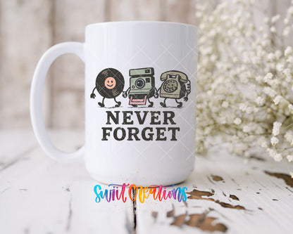 Never Forget UV DTF transfer on a 15 oz white ceramic mug beside white flowers