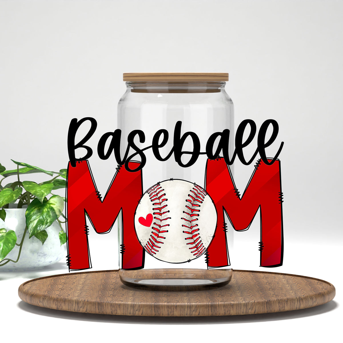 Baseball Mom red letters and baseball UV DTF transfer on a clear glass can