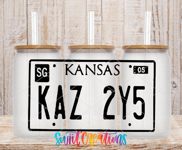 three kansas license plates on a wooden table