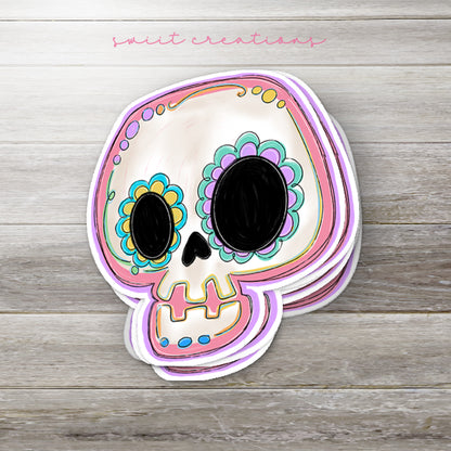 Stack of Pastel Sugar Skull glossy stickers on a gray wood table