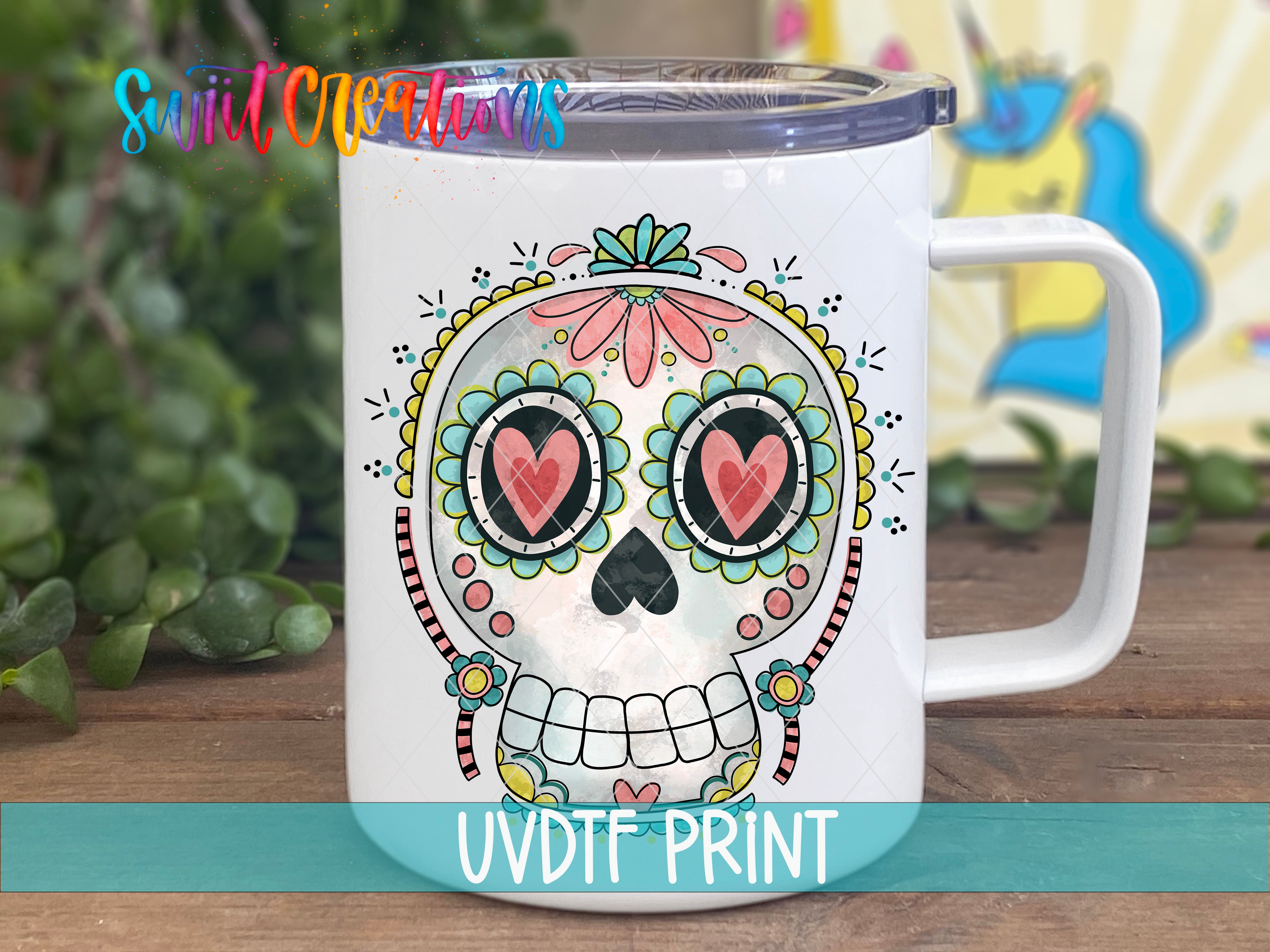 A white ceramic mug with a colorful, intricate design of a skull and floral patterns.