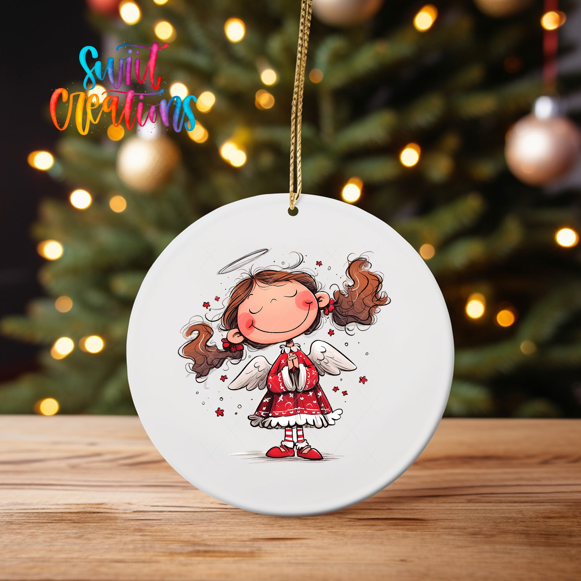 A white ceramic ornament featuring a smiling cartoon girl with curly hair and wings, set against a blurred background of Christmas lights.