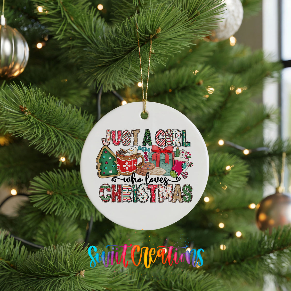 A Christmas tree decorated with ornaments, including a white ornament with text that says "Just a girl who loves Christmas".