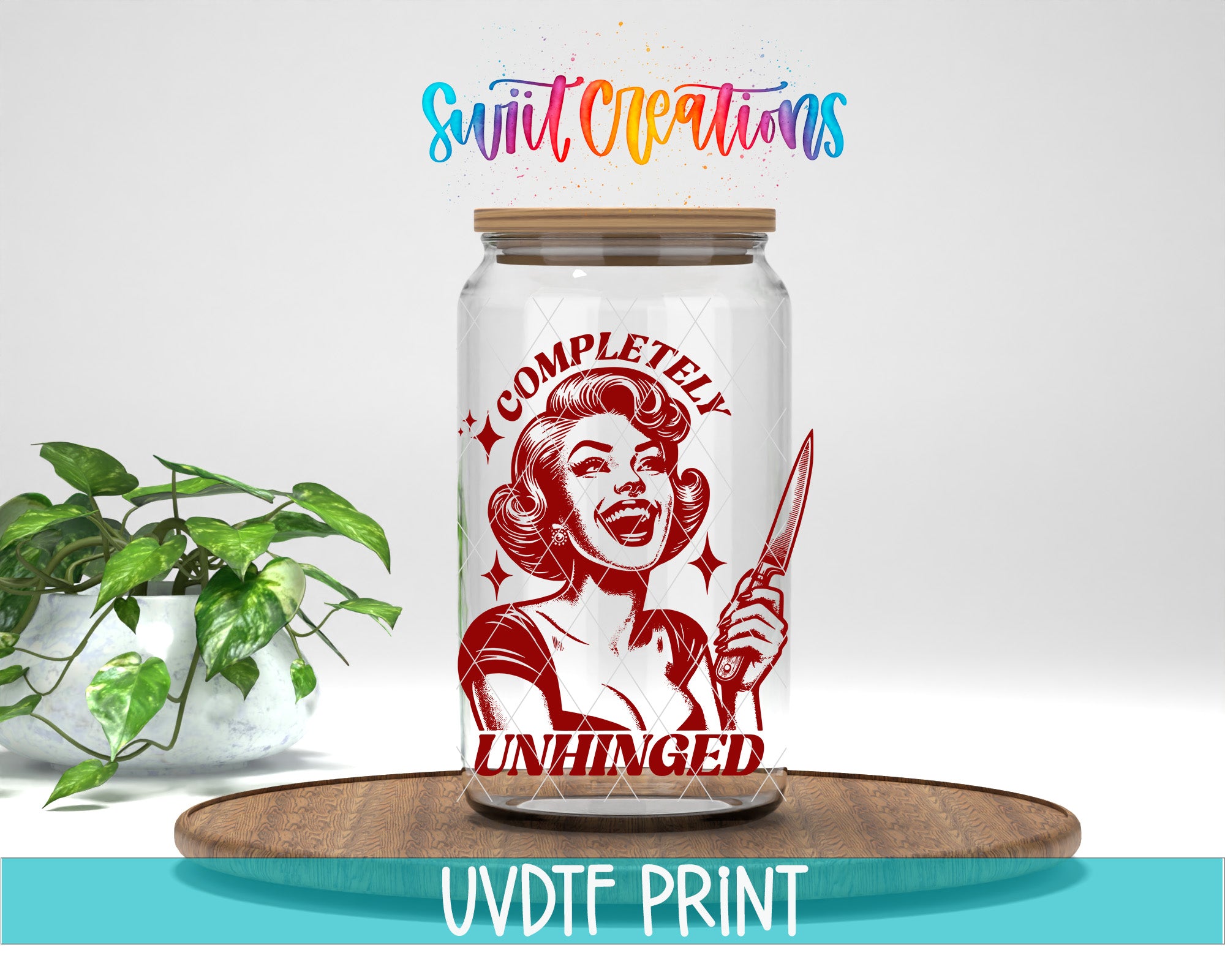 a glass jar with a red and white design, including a woman holding a knife and the text "COMPLETELY UNHINGED". The jar is placed on a wooden surface, and there is a potted plant in the background.