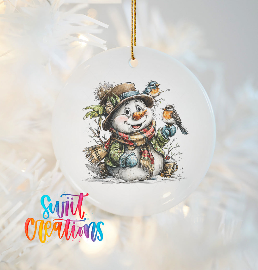 A snowman ornament with a bird perched on its head, wearing a hat and scarf, is hanging on a Christmas tree.