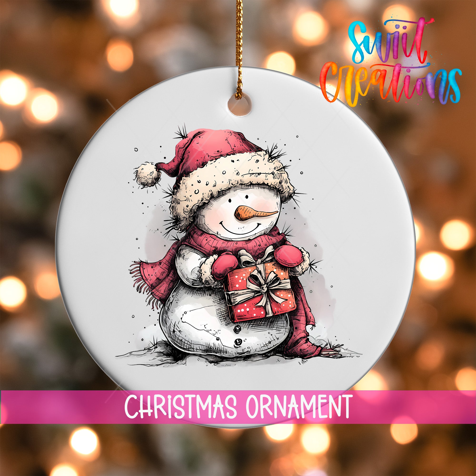 A white Christmas ornament featuring a snowman holding a gift, with a pink ribbon around it.