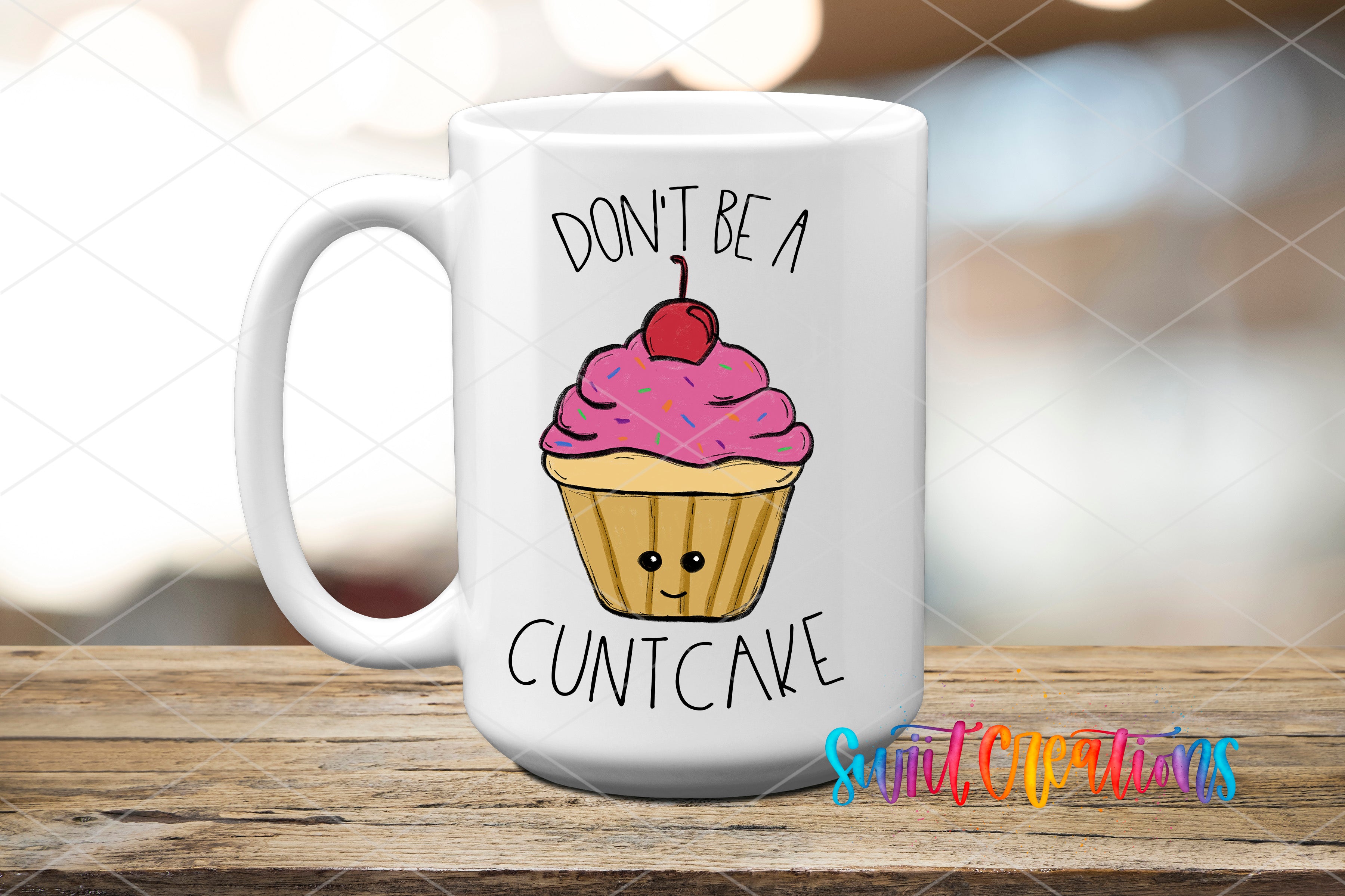 A white mug with a cartoon image of a cupcake and the text "DON'T BE A CUNTCAKE" printed on it.